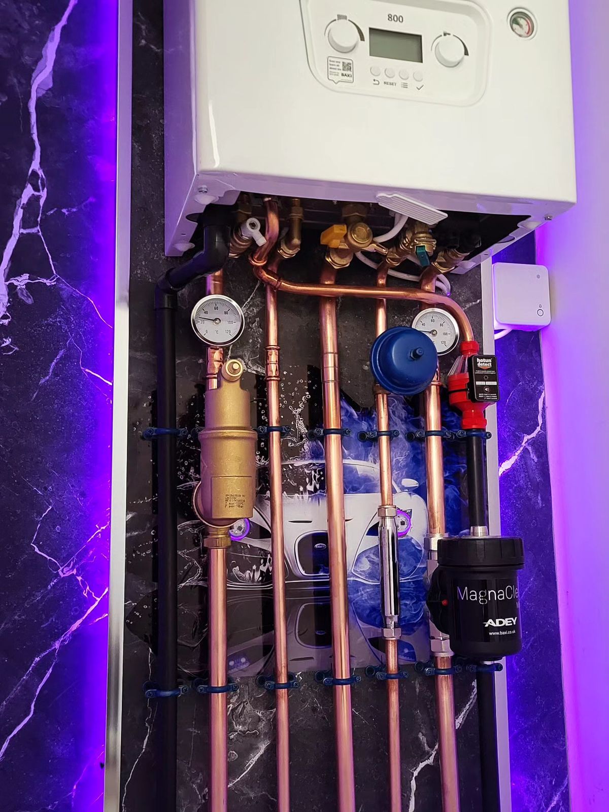 Upgraded heating system pipework, gauges and filter below a new boiler in Kettering